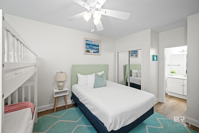 bedroom with ceiling fan, ensuite bath, and wood-type flooring