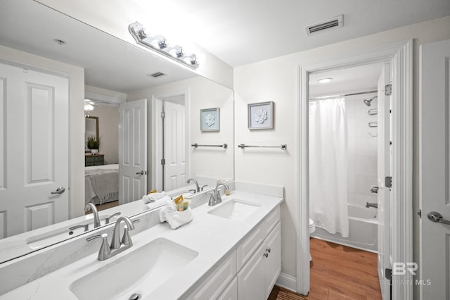 full bathroom featuring hardwood / wood-style flooring, toilet, shower / tub combo, and vanity