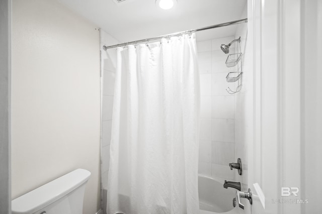 bathroom with shower / bath combo with shower curtain and toilet