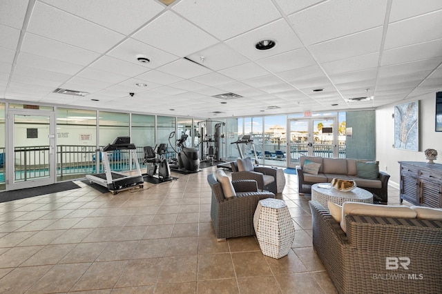 gym with a wall of windows, a paneled ceiling, and french doors