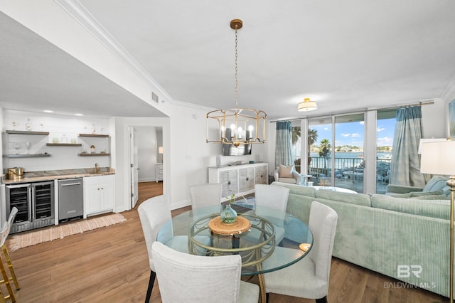 dining room with indoor bar, hardwood / wood-style floors, expansive windows, and beverage cooler