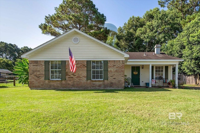 ranch-style house featuring brick siding, a chimney, covered porch, and a front yard