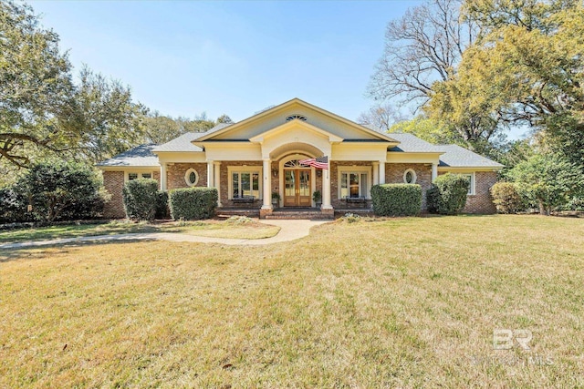 greek revival inspired property with a front lawn and brick siding