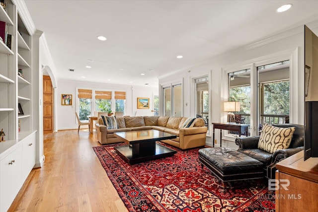 living area featuring recessed lighting, light wood-style floors, a wealth of natural light, and ornamental molding