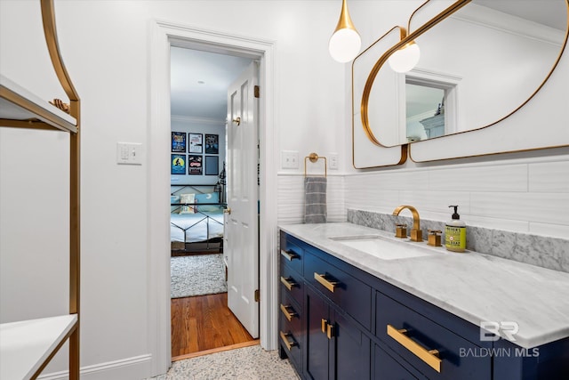 bathroom featuring vanity, speckled floor, and ornamental molding