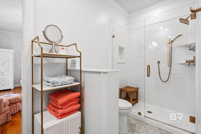 full bath featuring toilet, a stall shower, and crown molding