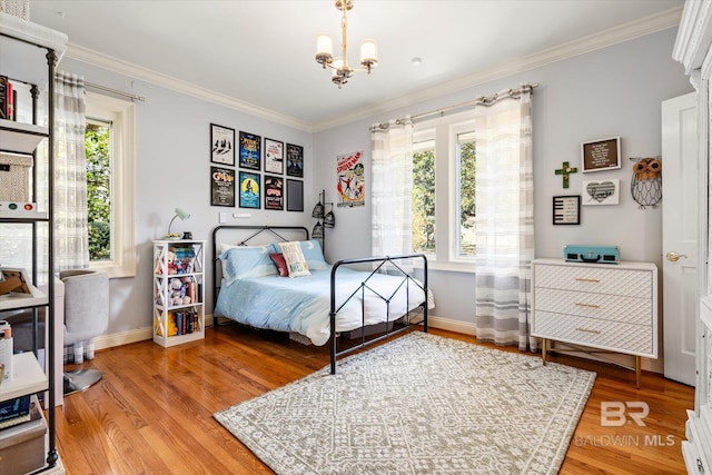 bedroom with a chandelier, baseboards, wood finished floors, and crown molding