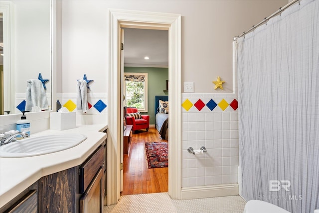 full bathroom featuring vanity, a shower with curtain, ornamental molding, ensuite bathroom, and tile walls