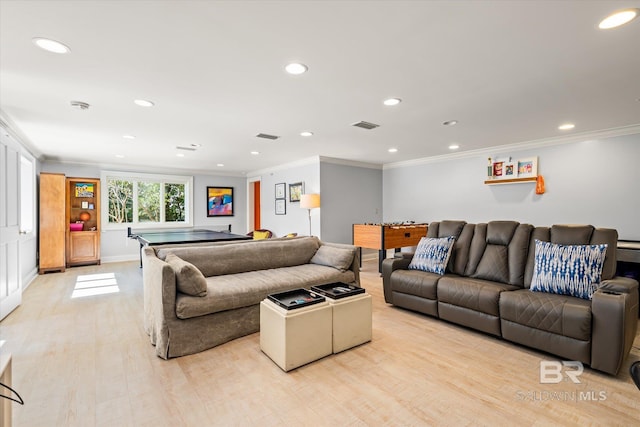 living area with crown molding, light wood-style floors, and visible vents