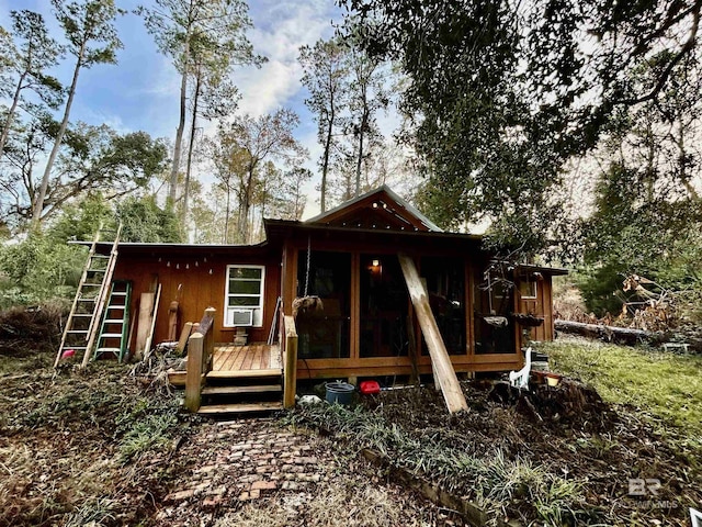 back of house with a wooden deck and a sunroom