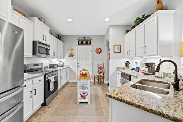 kitchen featuring light stone countertops, sink, white cabinetry, and stainless steel appliances