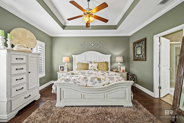 bedroom featuring ceiling fan, ornamental molding, dark wood-type flooring, and a tray ceiling