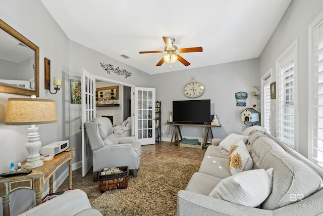 living room featuring french doors, dark tile patterned floors, and ceiling fan