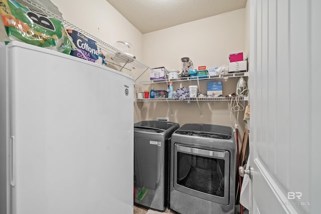 laundry area with a textured ceiling and washing machine and dryer