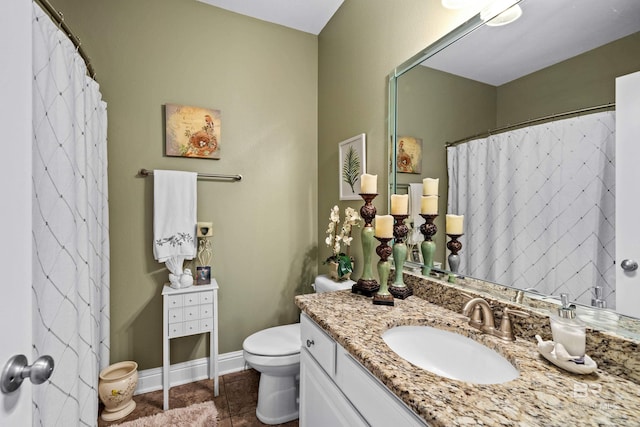 bathroom with toilet, vanity, and tile patterned floors