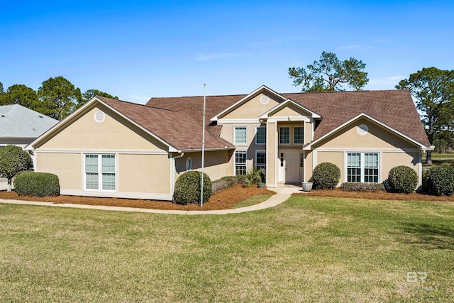 traditional-style house with a front lawn and stucco siding