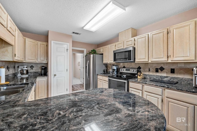 kitchen with tasteful backsplash, visible vents, dark stone counters, stainless steel appliances, and light brown cabinets