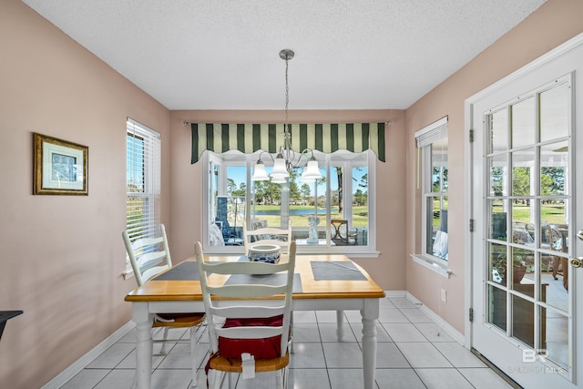 dining space featuring light tile patterned floors, baseboards, and a healthy amount of sunlight