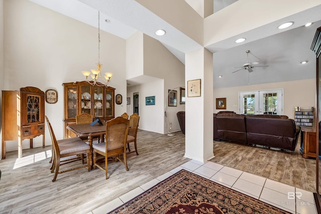 dining area with light wood-type flooring, recessed lighting, high vaulted ceiling, and ceiling fan with notable chandelier