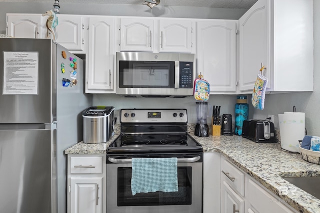 kitchen featuring white cabinetry, light stone countertops, and appliances with stainless steel finishes