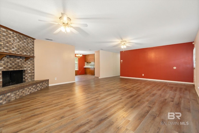 2405 Pavan Dr, Mobile, AL 36693 - unfurnished living room with visible vents, wood finished floors, a ceiling fan, and a fireplace