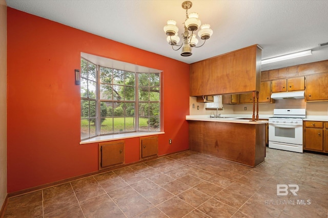 2405 Pavan Dr, Mobile, AL 36693 - kitchen featuring brown cabinets, white gas range, a chandelier, light countertops, and under cabinet range hood