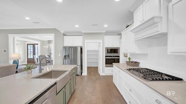 kitchen featuring sink, appliances with stainless steel finishes, white cabinetry, an inviting chandelier, and light stone counters