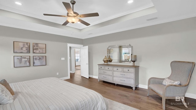 bedroom featuring a raised ceiling, ornamental molding, ceiling fan, and dark hardwood / wood-style flooring