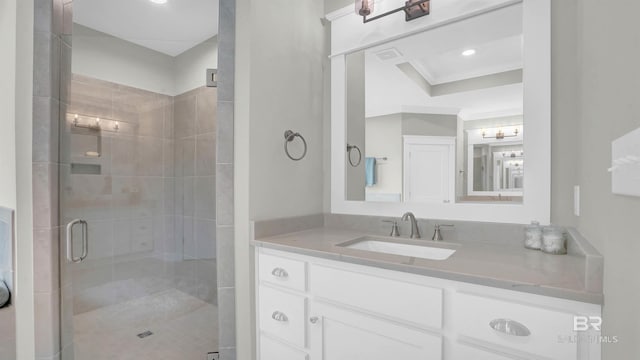 bathroom with vanity, crown molding, and walk in shower