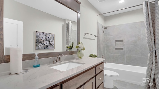 full bathroom featuring tiled shower / bath combo, vanity, and toilet