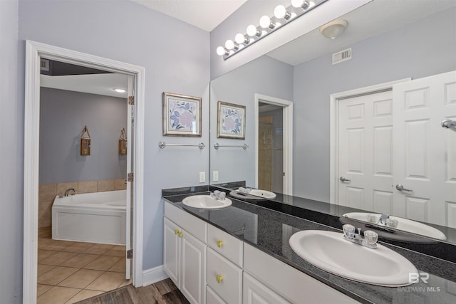 bathroom featuring vanity, tile patterned flooring, and a bathing tub