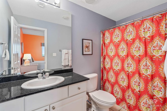 bathroom featuring vanity, toilet, and a textured ceiling