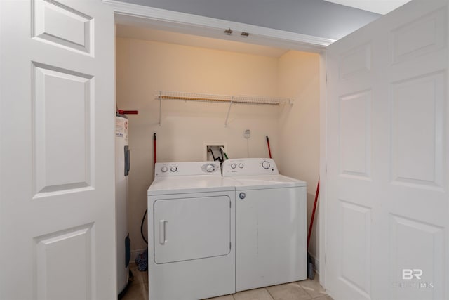 clothes washing area featuring electric water heater, washing machine and clothes dryer, and light tile patterned floors