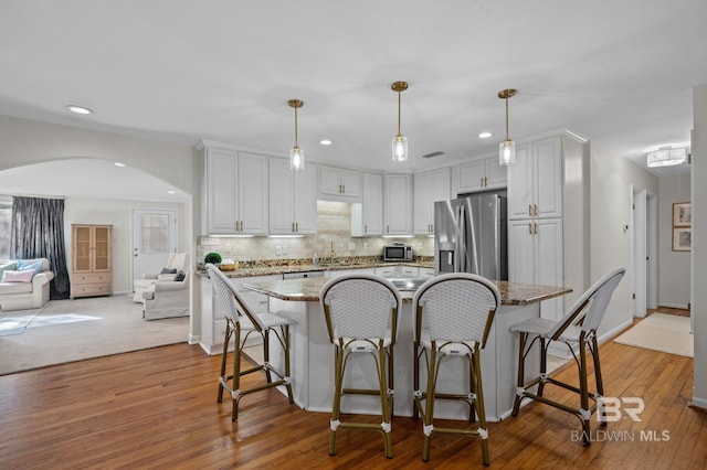 kitchen with white cabinets, stainless steel appliances, and hanging light fixtures