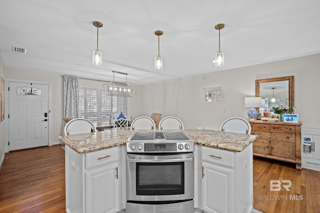 kitchen with a center island, white cabinets, pendant lighting, and stainless steel electric range