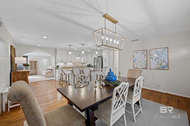 dining area featuring a notable chandelier and light hardwood / wood-style floors