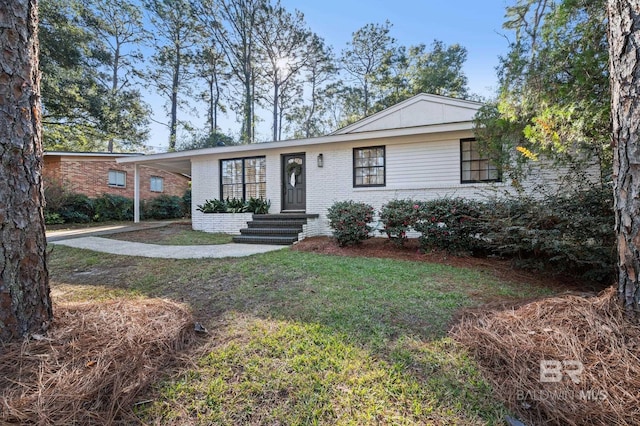 single story home with a front yard and a carport