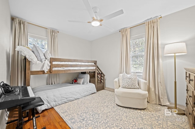 bedroom featuring multiple windows, hardwood / wood-style floors, and ceiling fan