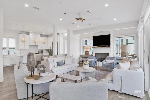 living area featuring visible vents, recessed lighting, light wood-style floors, and a fireplace
