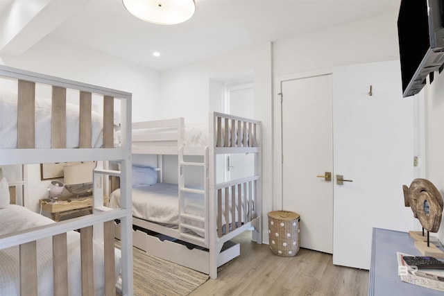 bedroom with recessed lighting, wood finished floors, and a closet