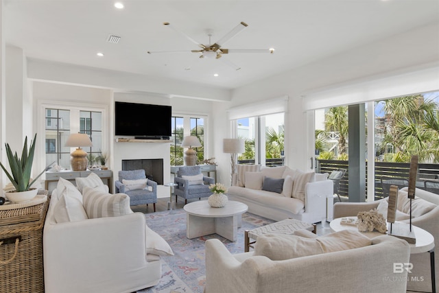 living area with recessed lighting, a healthy amount of sunlight, and a fireplace