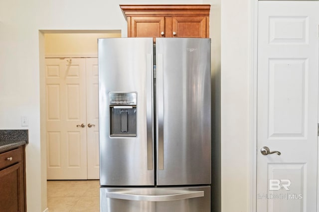 kitchen featuring light tile patterned flooring and stainless steel refrigerator with ice dispenser