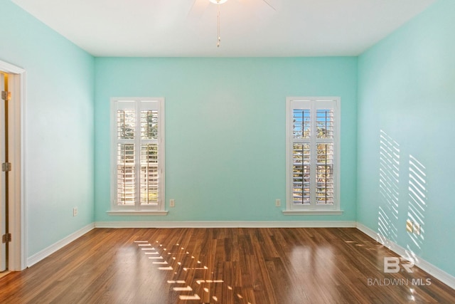 empty room with a healthy amount of sunlight and dark hardwood / wood-style flooring