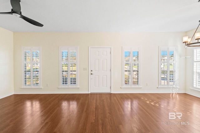 interior space with hardwood / wood-style flooring and ceiling fan with notable chandelier