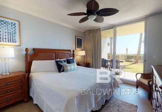 527C Beach Club Trl Unit C-0104, Gulf Shores, AL 36542 - bedroom with access to exterior, a textured ceiling, wood finished floors, a ceiling fan, and crown molding