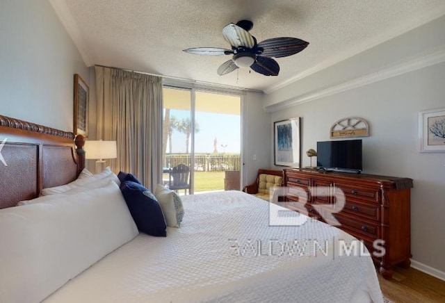 527C Beach Club Trl Unit C-0104, Gulf Shores, AL 36542 - bedroom with access to outside, a textured ceiling, wood finished floors, ornamental molding, and a ceiling fan