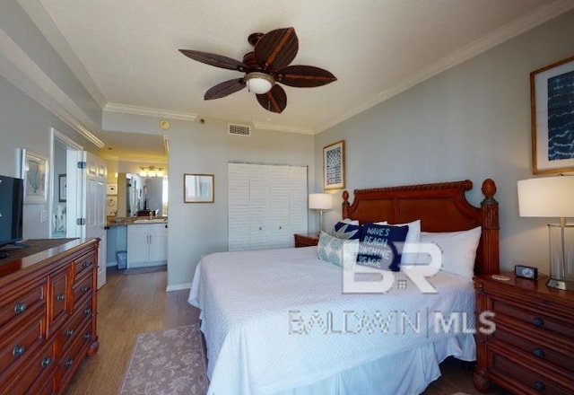 527C Beach Club Trl Unit C-0104, Gulf Shores, AL 36542 - bedroom featuring wood finished floors, crown molding, a ceiling fan, and ensuite bath