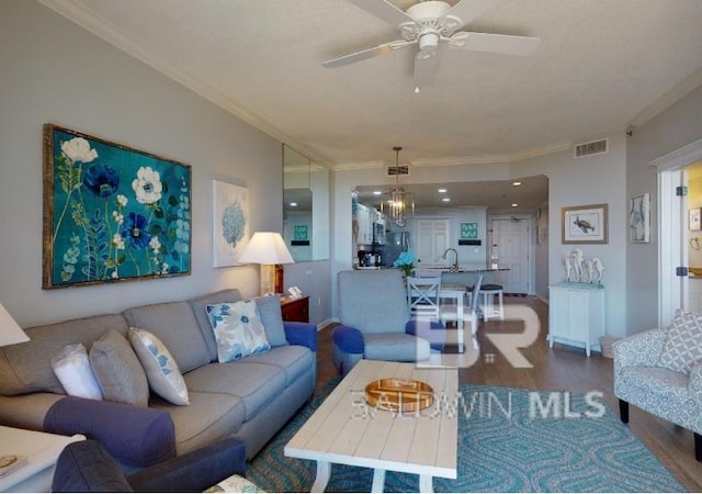 527C Beach Club Trl Unit C-0104, Gulf Shores, AL 36542 - living room featuring ornamental molding, wood finished floors, ceiling fan, and a chandelier