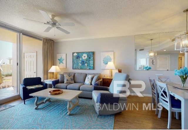 527C Beach Club Trl Unit C-0104, Gulf Shores, AL 36542 - living room with a textured ceiling, ceiling fan, a chandelier, and wood finished floors