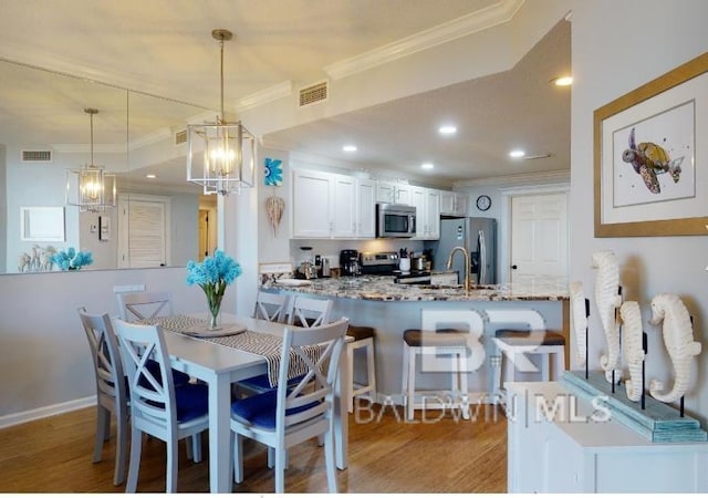 527C Beach Club Trl Unit C-0104, Gulf Shores, AL 36542 - dining area with ornamental molding, light wood-style floors, a chandelier, and recessed lighting